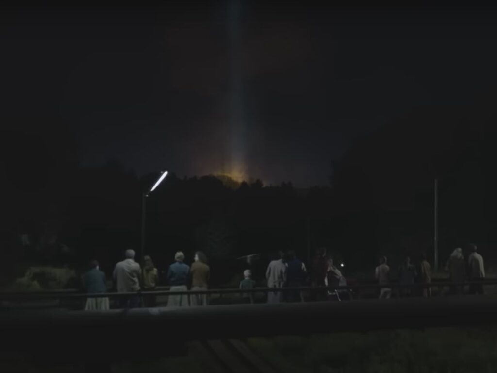 Civilians watch as an explosion happens