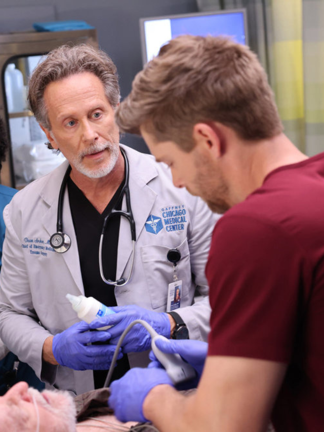 Archer wearing purple gloves and holding a bottle and looking at Ripley while they work together on a patient on Chicago Med Season 10 Episode 2