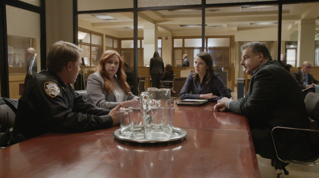 Erin and Reagan meet with a coup and a red-haired woman in a suit on Blue Bloods Season 14 Episode 12