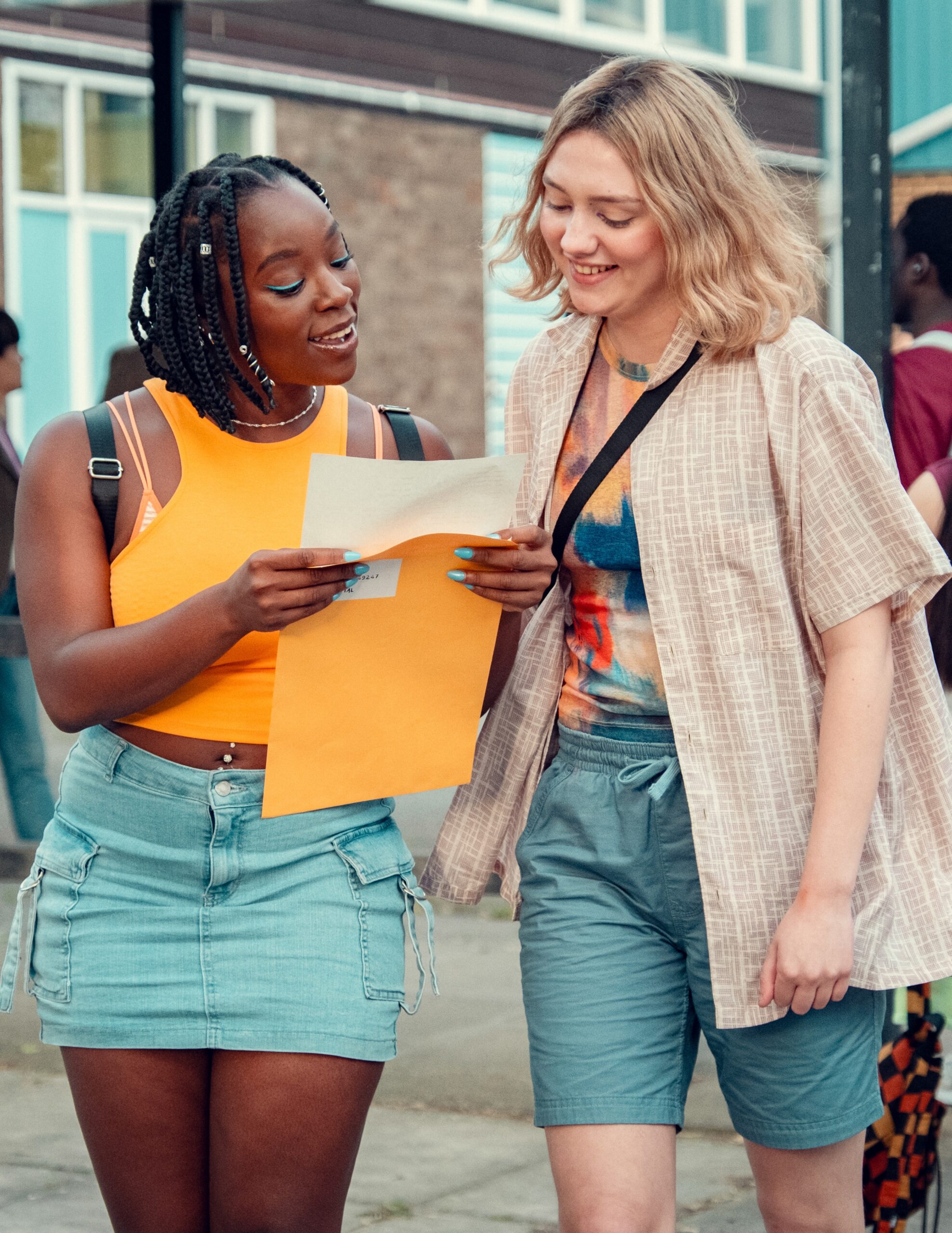 Tara and Darcy smiling as they walk with Tara's GCSE results