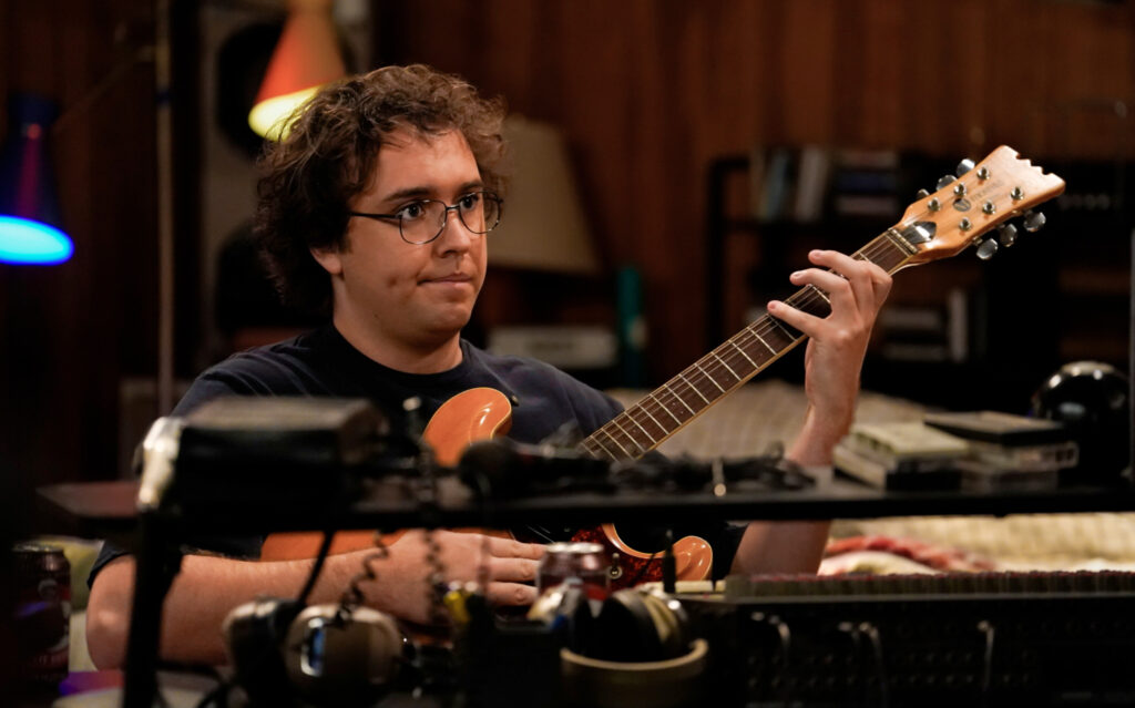 Connor playing the guitar on Georgie & Mandy's First Marriage Season 1 Episode 15