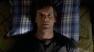 Peter Krause lying in bed as Nate Fisher on Six Feet Under, staring upward in a scene just after his death
