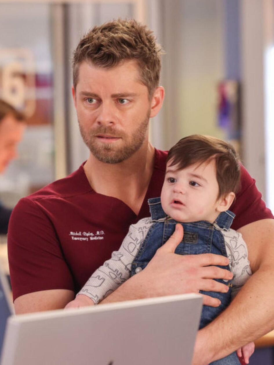 Frost and Ripley stand by the nurse's station on Chicago Med Season 10 Episode 21. Ripley is holding a baby.
