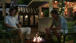Conrad and Adam talk to each other at a fire pit about the failed wedding.