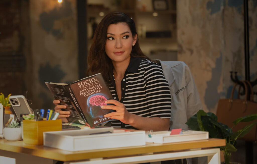 Sasha smirks while reading about anti-social personality disorder on Watson Season 2 EPisode 3
