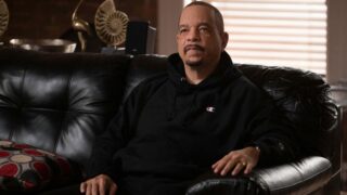 Fin sits on a couch talking to someone offscreen on Law & Order: SVU Season 27 Episode 3