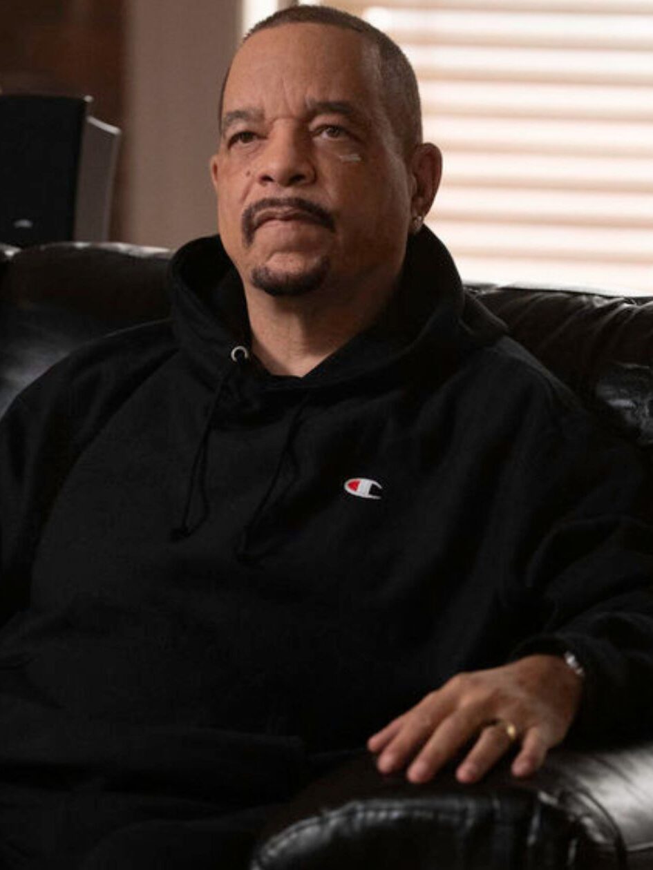Fin sits on a couch talking to someone offscreen on Law & Order: SVU Season 27 Episode 3