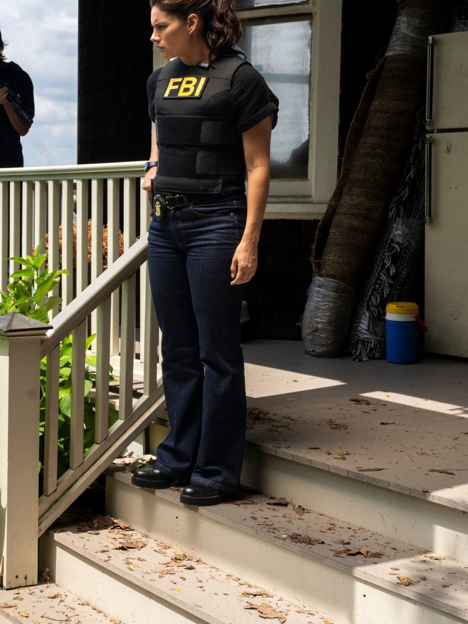 Maggie standing on the steps of a house by the water on FBI Season 8 Episode 1