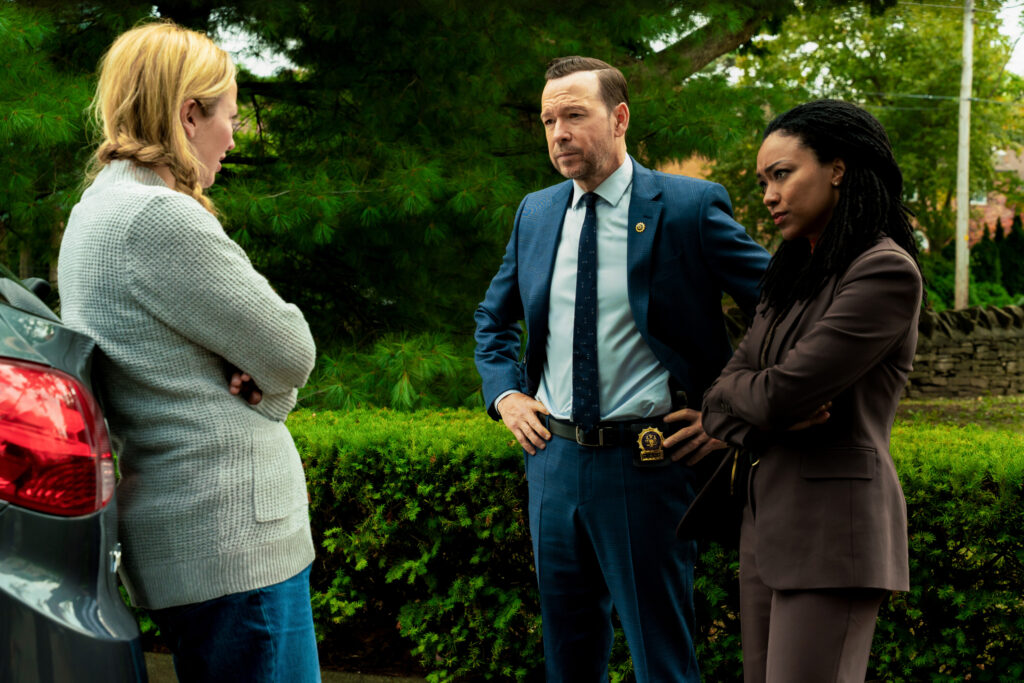 Dani and Leena question someone by a car in a green park on Boston Blue Season 1 Episode 5