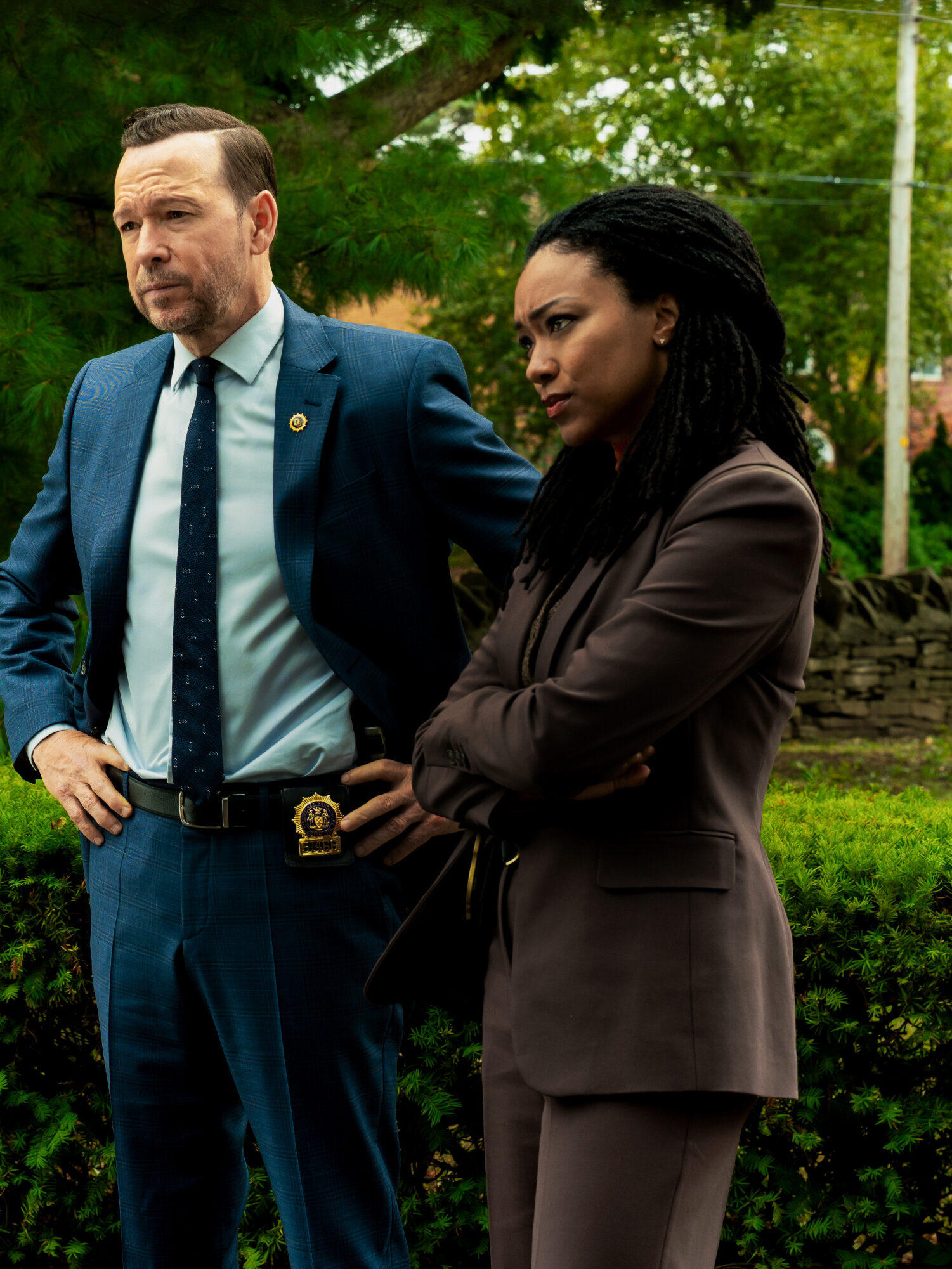 Dani and Leena question someone by a car in a green park on Boston Blue Season 1 Episode 5