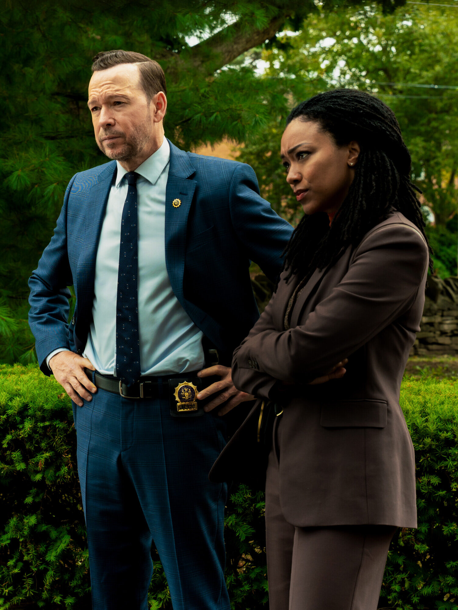 Danny and Lena question someone by a car in a green park on Boston Blue Season 1 Episode 5