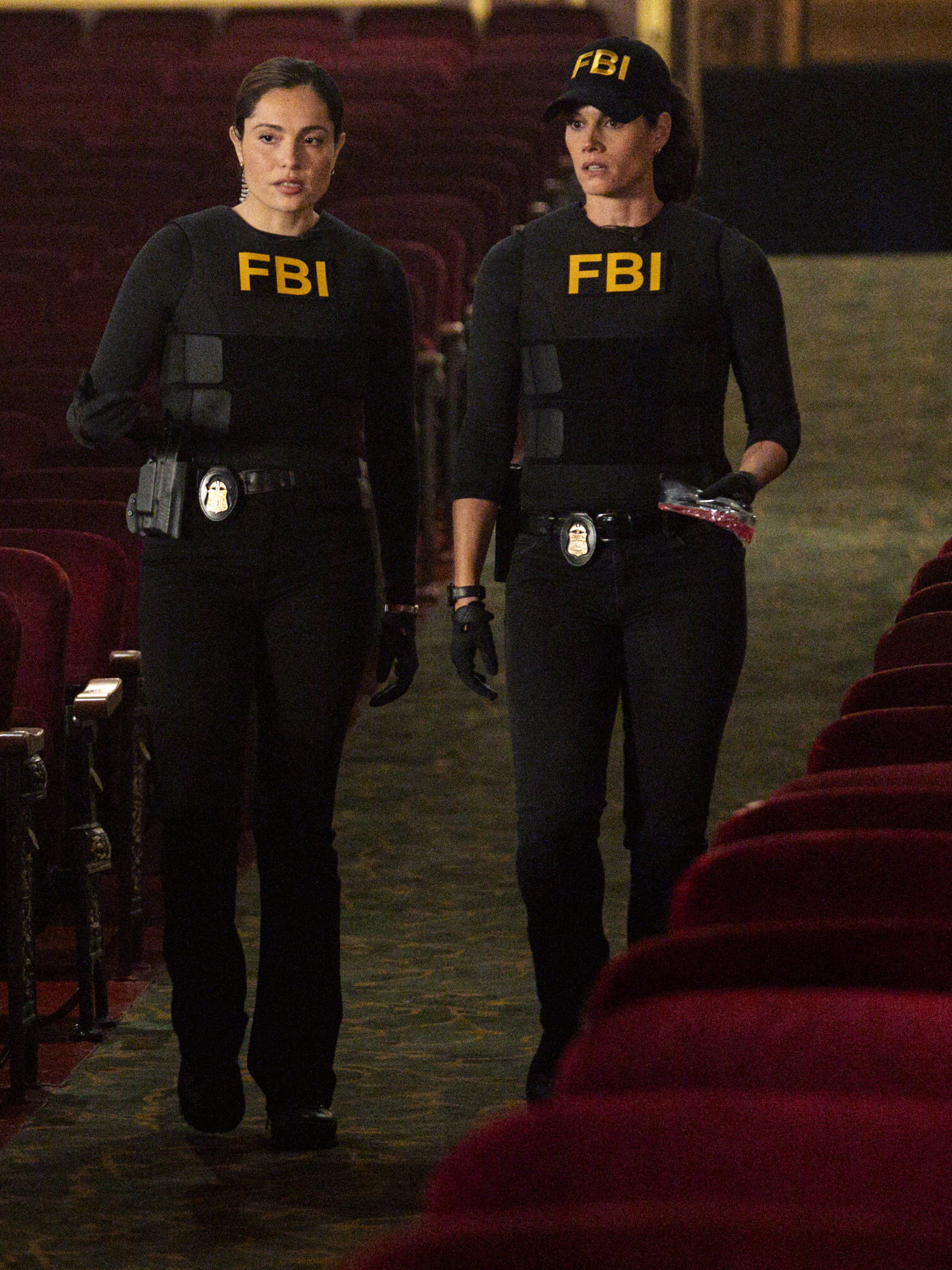 Maggie and Eva walk through a theater that appears to be a crime scene on FBI Season 8 Episode 5