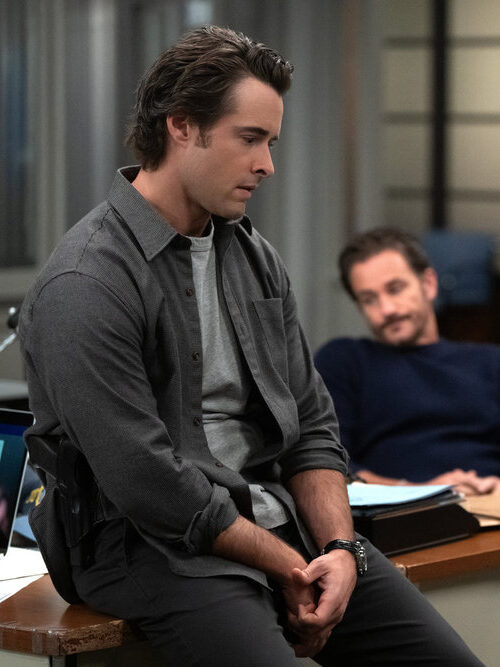 Griffin sitting on the edge of his desk on Law & Order: SVU Season 27 Episode 8