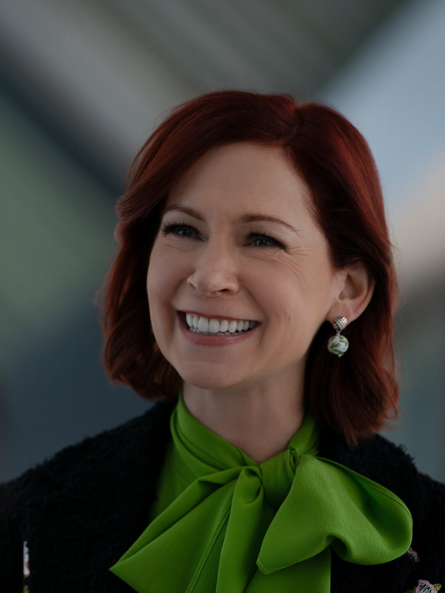 Elsbeth with a wide smile and green scarf on Elsbeth Season 3 Episode 8