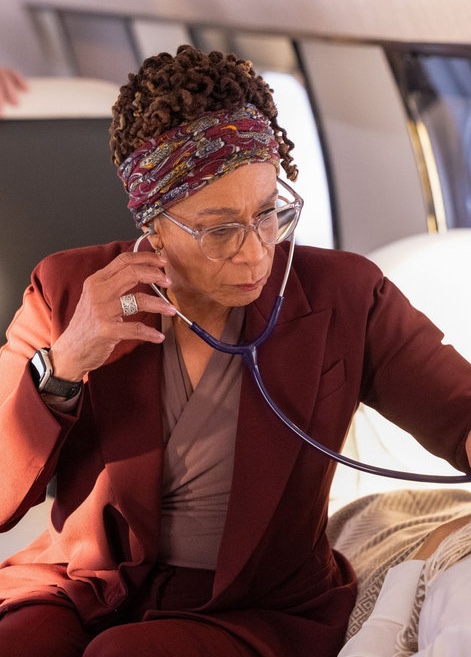 Sharon checks someone's vital signs on a plane on Chicago Med Season 11 Episode 12